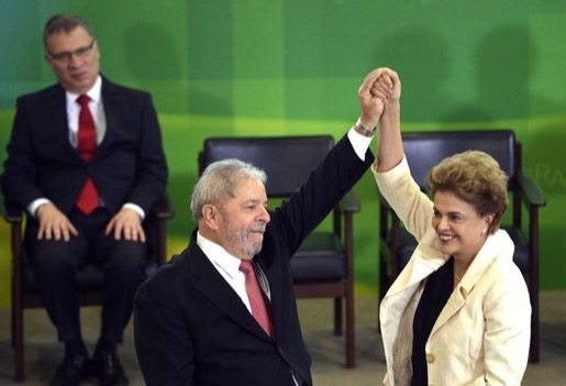 Presidente Dilma Rousseff durante cerimônia de posse dos novos ministros ergue o braço em sinal de vitória do novo ministro da Casa Civil, Luiz Inácio Lula da Silva. Foto: José Cruz / Agência Brasil